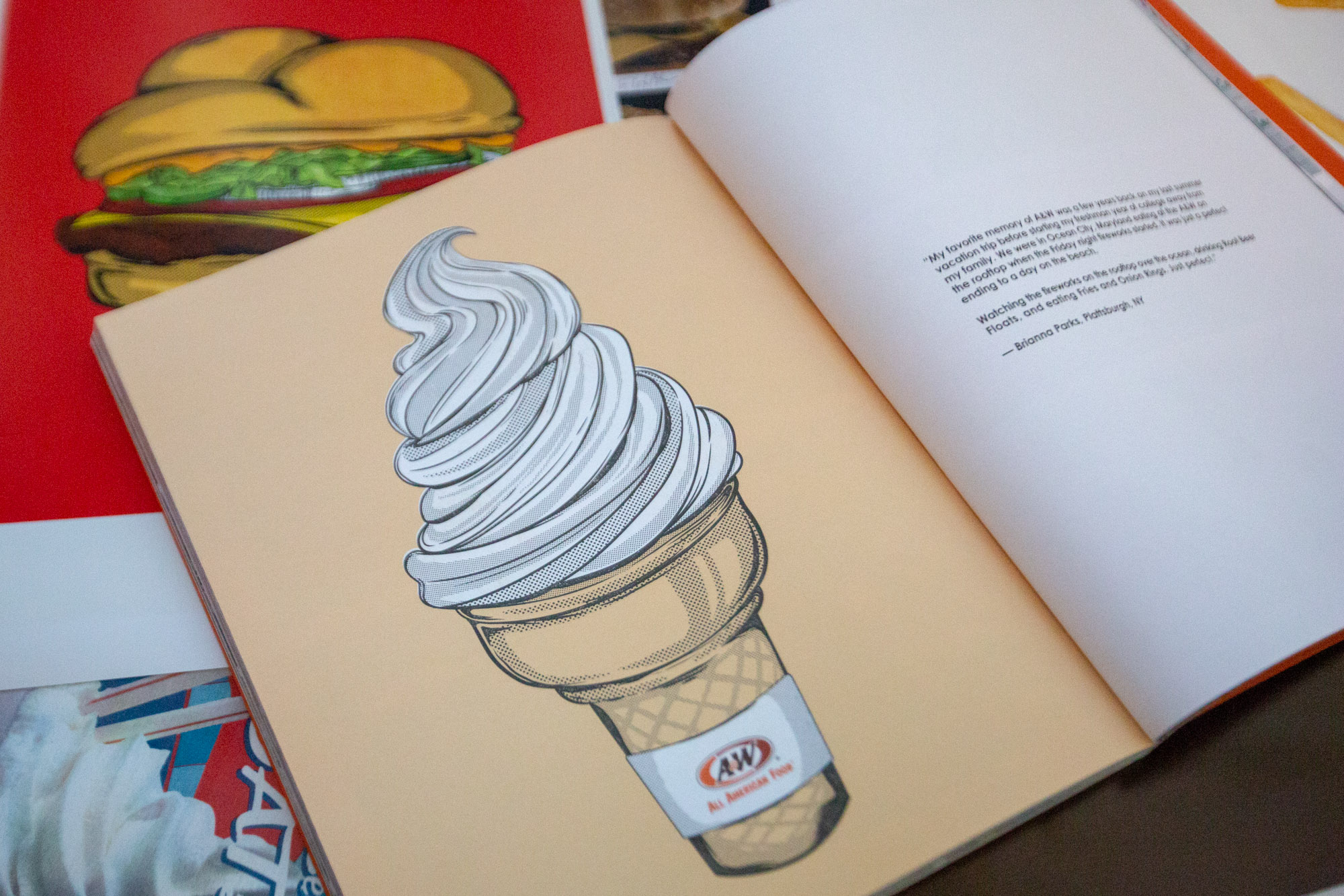 A&W 100th Anniversary Book with drawing of a vanilla soft serve cone on the left page, fan story on the right page.