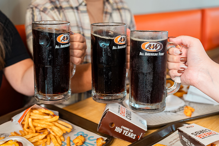 3 people toasting with mugs of A&W Root Beer