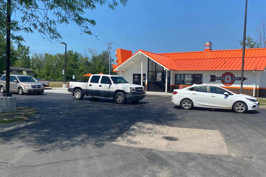 Exterior photo of A&W Restaurant in Beaverton, Michigan. Cars are lined up in the drive-thru.