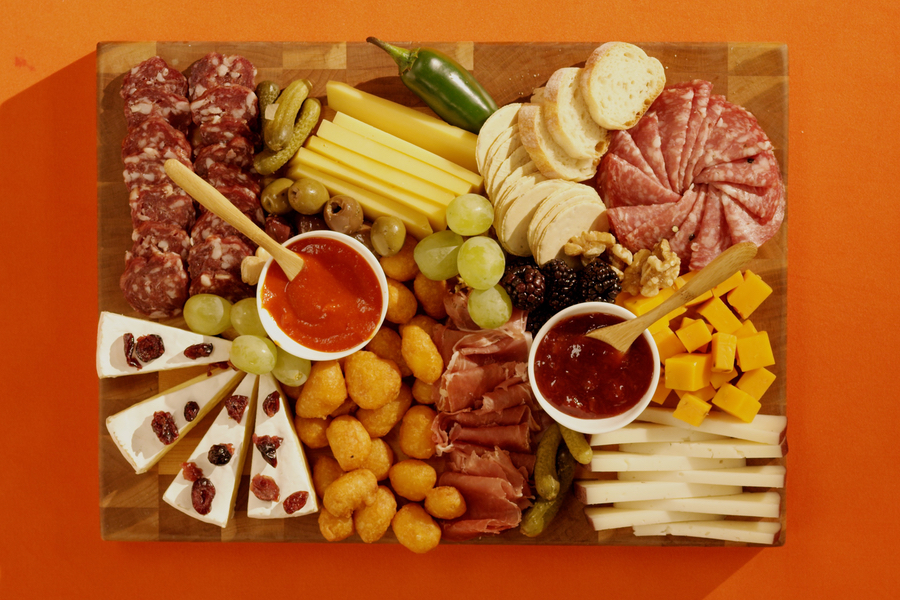 Overhead photo of the Game Day Char-curd-erie Board on an orange background.