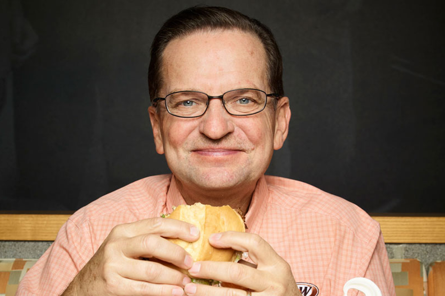 Photo of CEO Kevin Bazner holding an A&W burger.