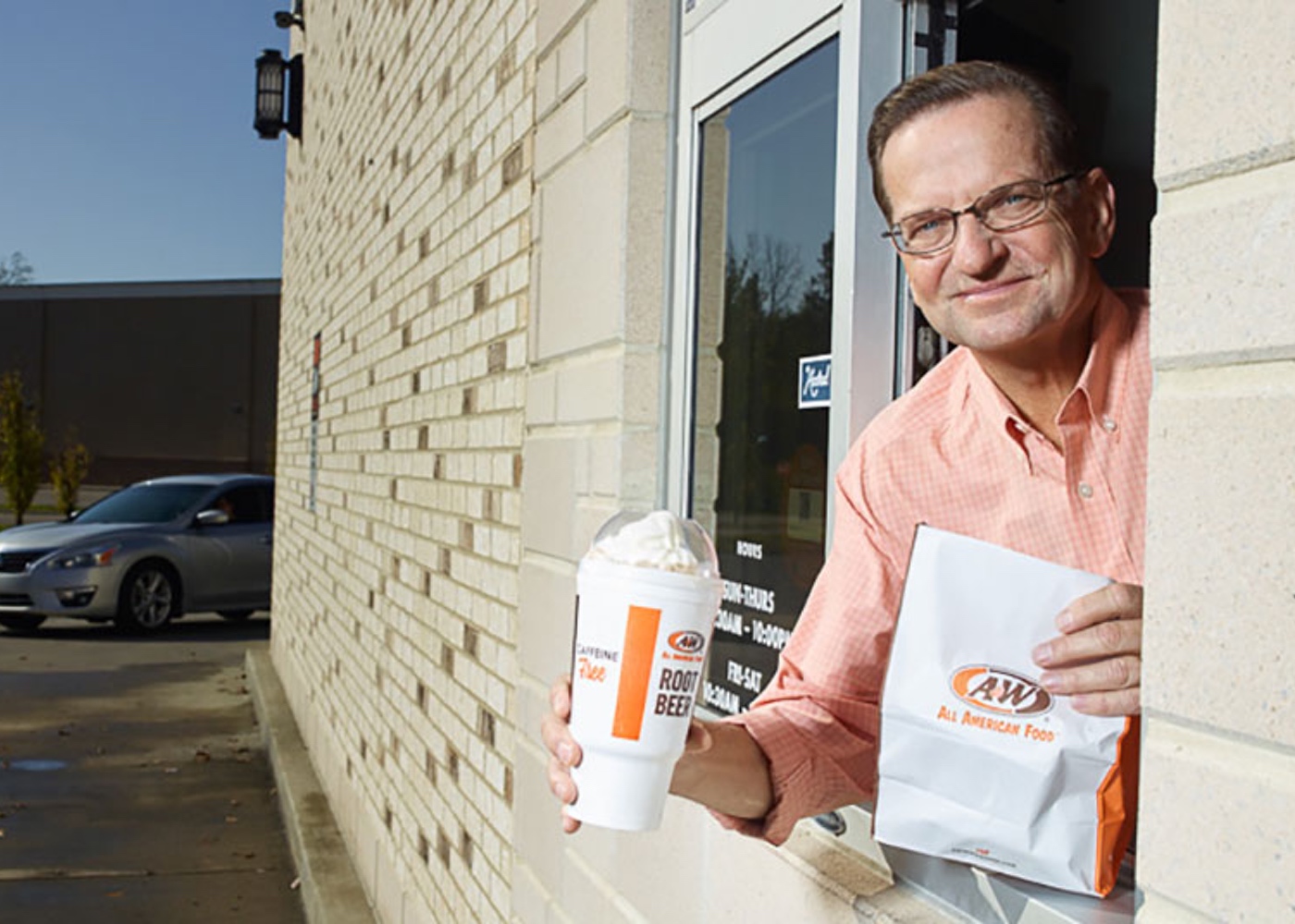 Photo of Kevin Bazner in drive-thru holding Root Beer Float and A&W to-go bag